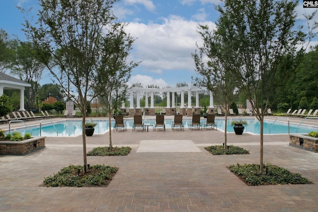 community pool with a patio area and a pergola
