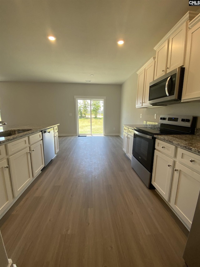 kitchen featuring white cabinets, a sink, stainless steel appliances, recessed lighting, and dark wood finished floors