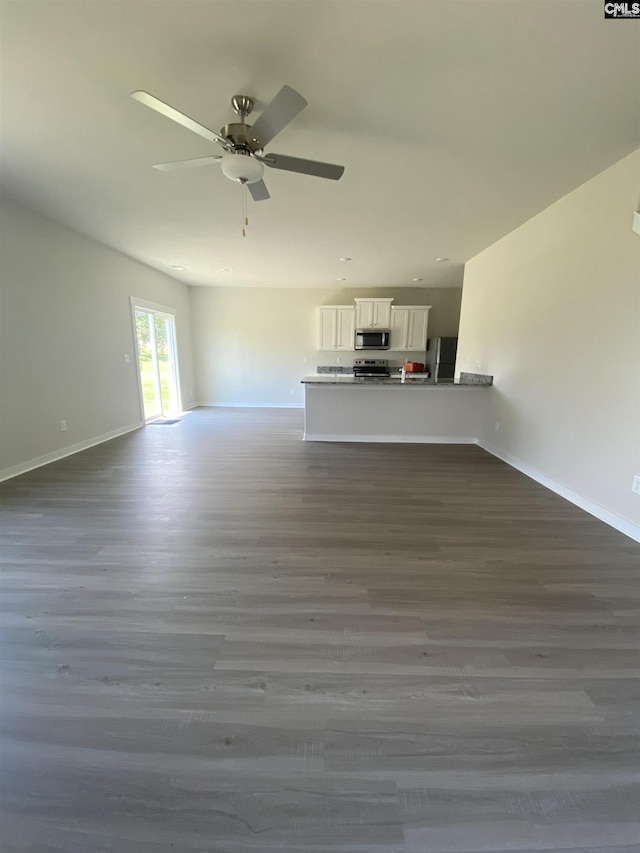 unfurnished living room with a ceiling fan, dark wood-style flooring, and baseboards