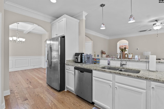 kitchen featuring a sink, beam ceiling, light wood-type flooring, arched walkways, and appliances with stainless steel finishes