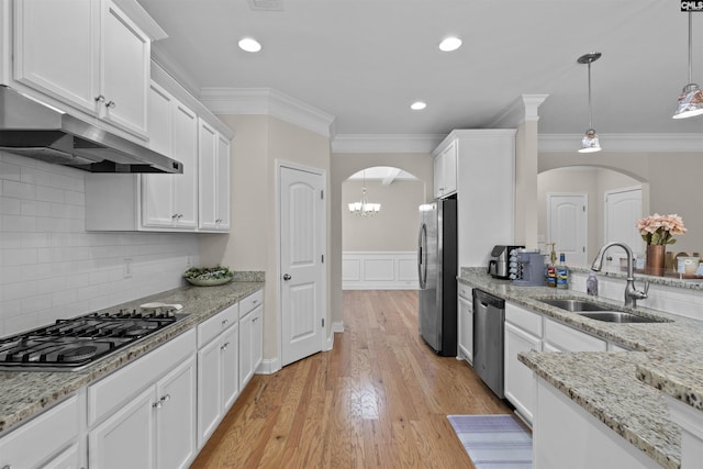 kitchen featuring a sink, stainless steel appliances, under cabinet range hood, and arched walkways