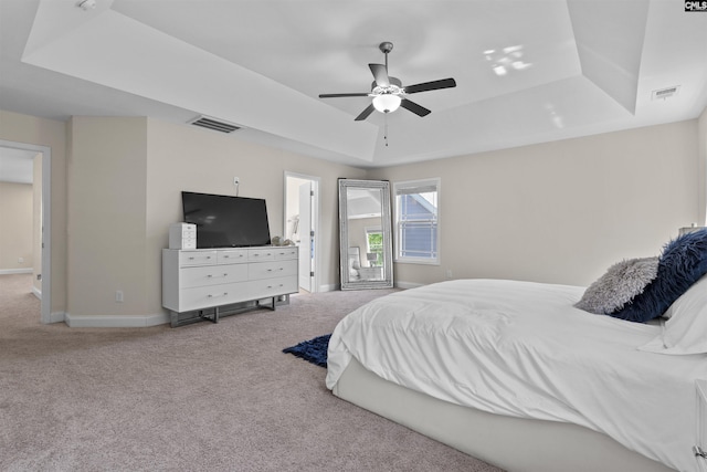 bedroom with visible vents, baseboards, a tray ceiling, and carpet flooring