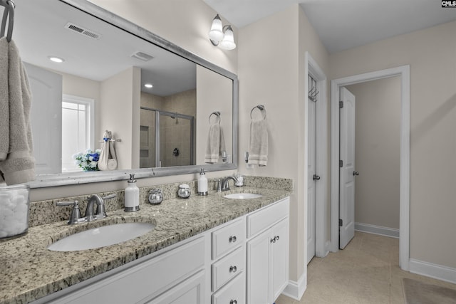 bathroom featuring a sink, a shower stall, tile patterned floors, and visible vents