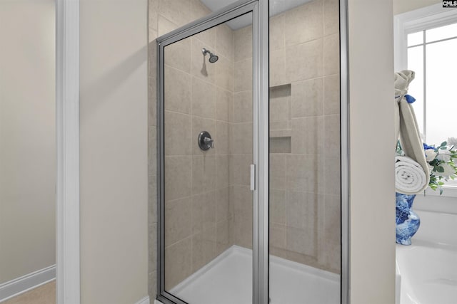 bathroom featuring a stall shower and a bathtub