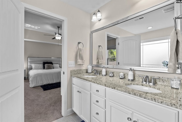 full bathroom with a ceiling fan, a sink, double vanity, and ensuite bathroom