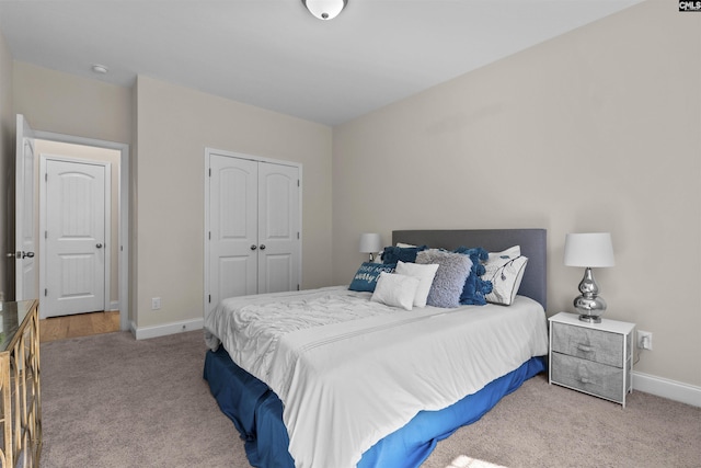 bedroom with baseboards, a closet, and carpet