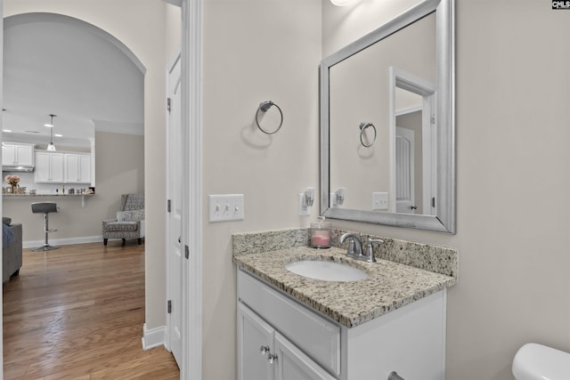 half bath with recessed lighting, wood finished floors, toilet, vanity, and baseboards