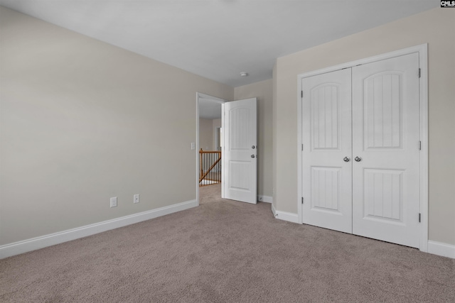 unfurnished bedroom featuring a closet, carpet flooring, and baseboards