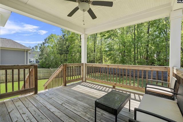 wooden deck with ceiling fan, a fenced backyard, and a yard