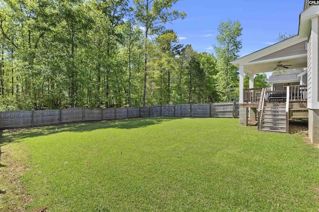 view of yard with a deck, stairway, ceiling fan, and a fenced backyard