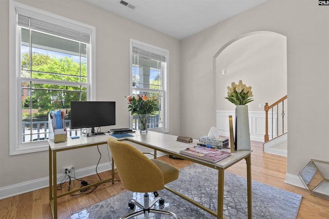office with baseboards, visible vents, and wood finished floors