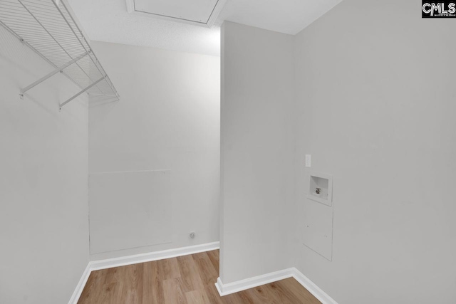 clothes washing area featuring hookup for a washing machine, wood finished floors, laundry area, and baseboards