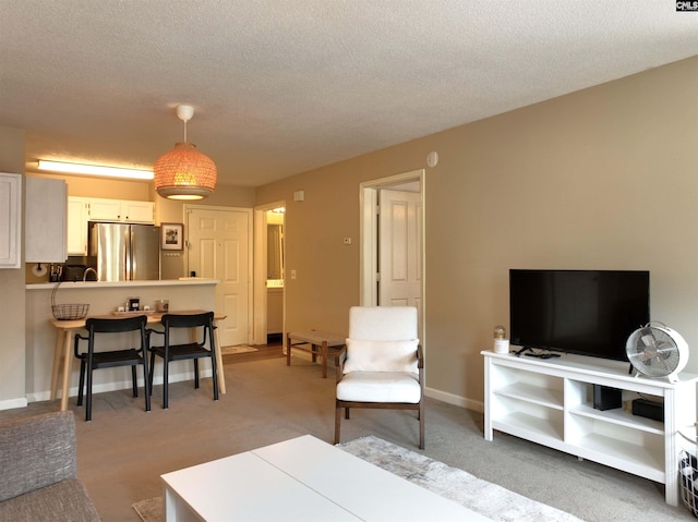 900 Taylor St Unit 304, Columbia, SC 29201 - carpeted living room featuring a textured ceiling and baseboards