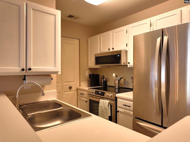 900 Taylor St Unit 304, Columbia, SC 29201 - kitchen featuring white cabinets, a sink, appliances with stainless steel finishes, visible vents, and light countertops