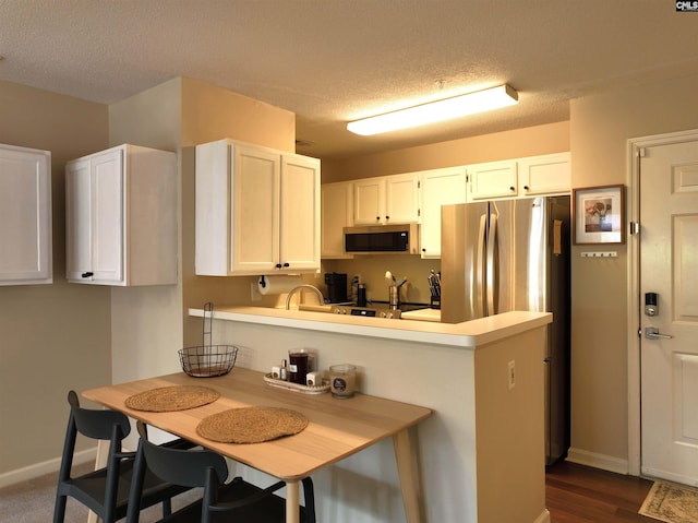 900 Taylor St Unit 304, Columbia, SC 29201 - kitchen with baseboards, stainless steel appliances, light countertops, white cabinetry, and a textured ceiling
