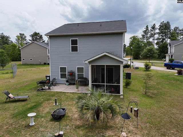 rear view of property featuring a patio, a sunroom, and a lawn