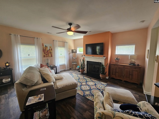 living room with a fireplace with flush hearth, wood finished floors, ceiling fan, and plenty of natural light