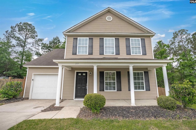 traditional home featuring a porch, concrete driveway, a garage, and fence