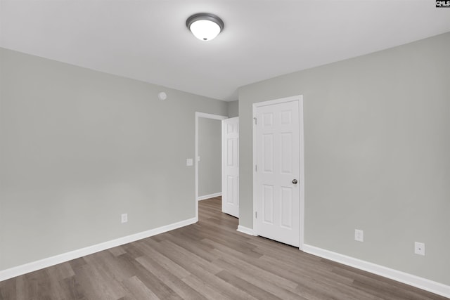unfurnished room with baseboards and wood finished floors