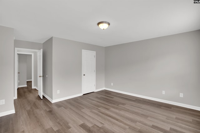 unfurnished bedroom featuring wood finished floors and baseboards