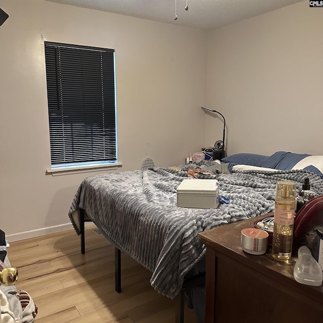 bedroom featuring light wood-style flooring and baseboards