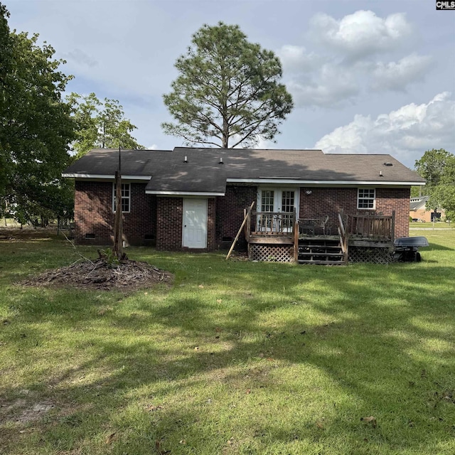 rear view of property featuring brick siding, a wooden deck, and a lawn