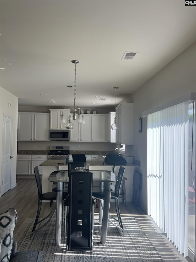 dining space with dark wood-style flooring and visible vents