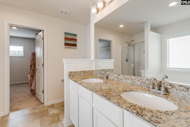 bathroom featuring visible vents, a sink, baseboards, and a shower stall