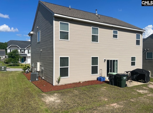 back of property with a patio, central air condition unit, and a yard