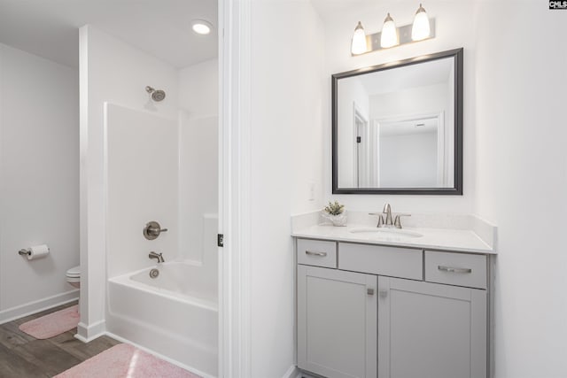 full bath with vanity, shower / bathtub combination, toilet, baseboards, and wood finished floors