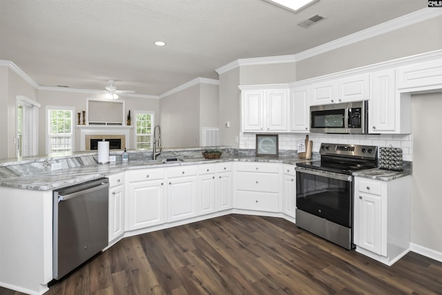 kitchen with light stone counters, a sink, visible vents, stainless steel appliances, and dark wood finished floors