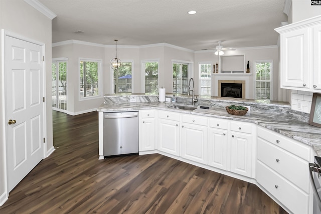 kitchen with a sink, a tiled fireplace, dark wood-type flooring, dishwasher, and ceiling fan with notable chandelier