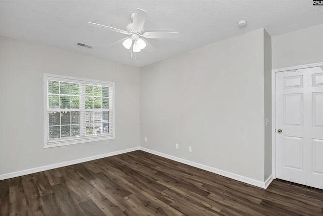 spare room with ceiling fan, baseboards, and dark wood finished floors