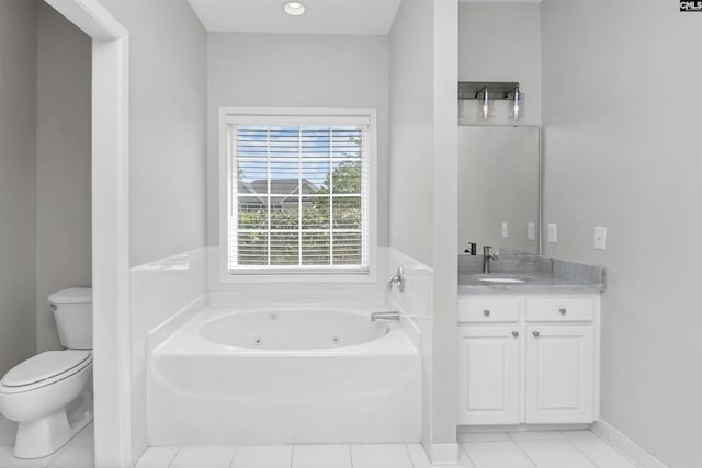 bathroom featuring toilet, tile patterned flooring, a tub with jets, and vanity