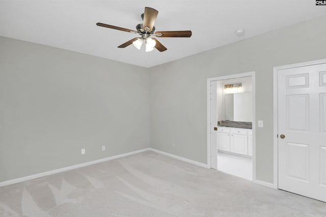 unfurnished bedroom with baseboards, a ceiling fan, connected bathroom, and light colored carpet