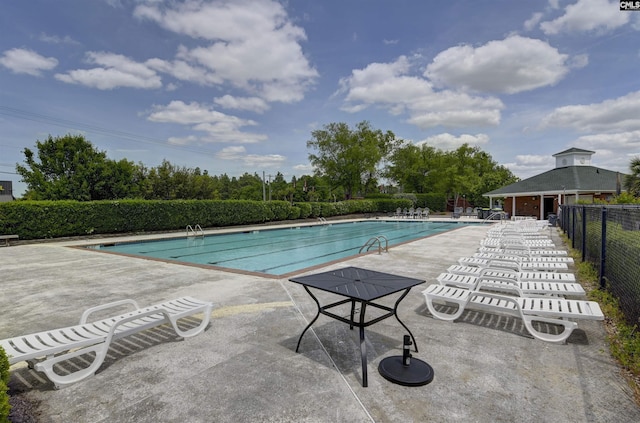 community pool featuring fence and a patio area