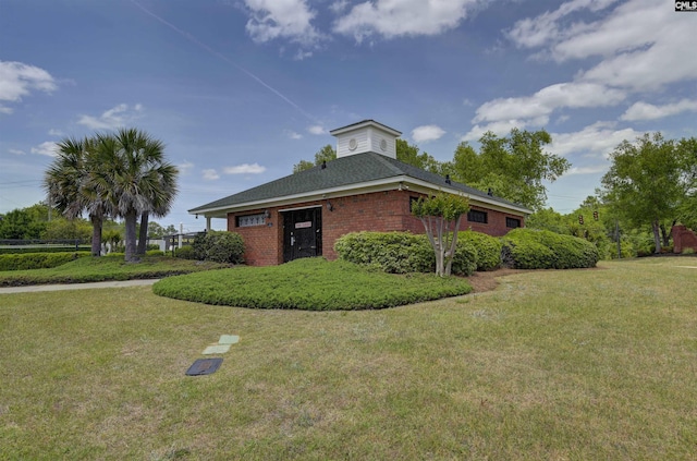 view of property exterior with a lawn and brick siding