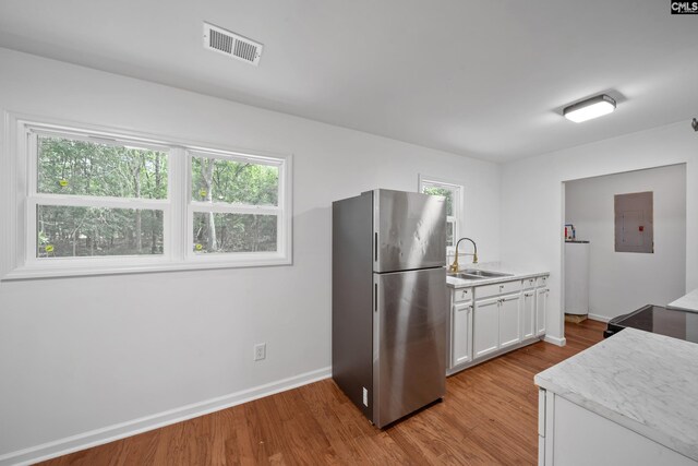1203 Basil Rd, Swansea, SC 29160 - kitchen with a sink, visible vents, electric panel, freestanding refrigerator, and light wood-type flooring