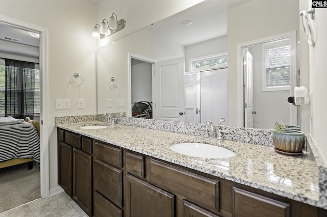 bathroom featuring visible vents, connected bathroom, double vanity, and a sink