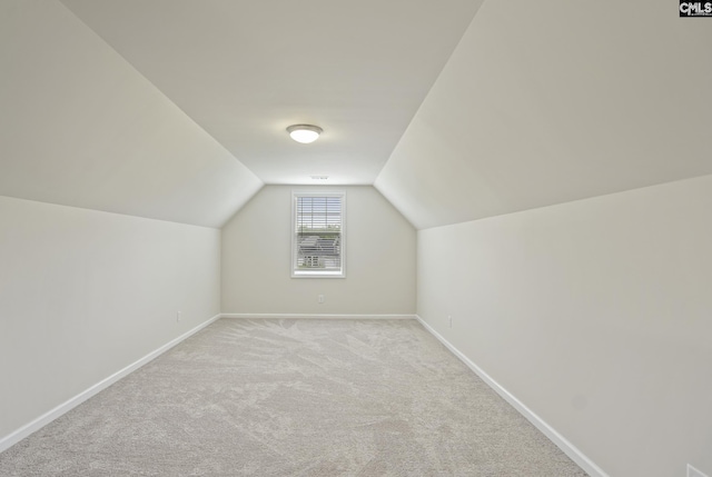 bonus room featuring lofted ceiling, light carpet, and baseboards