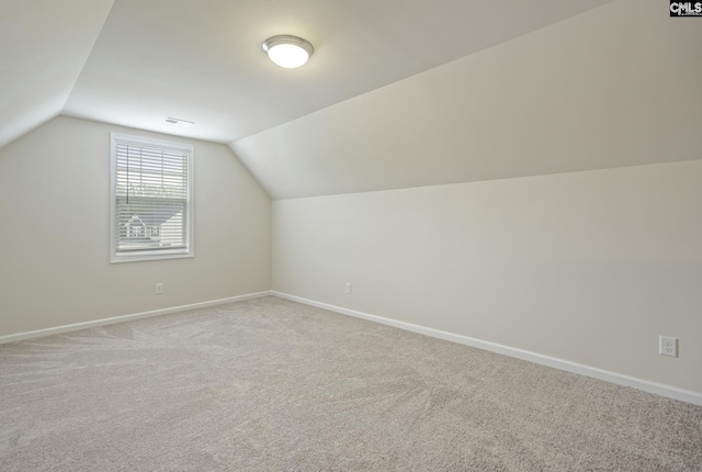 additional living space featuring visible vents, carpet flooring, lofted ceiling, and baseboards