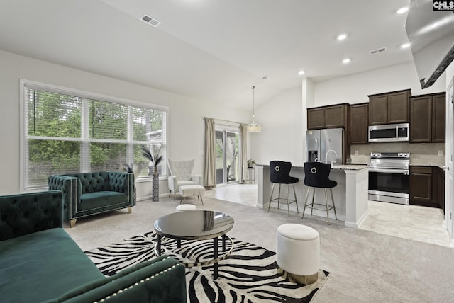 living room with light colored carpet, visible vents, recessed lighting, and vaulted ceiling