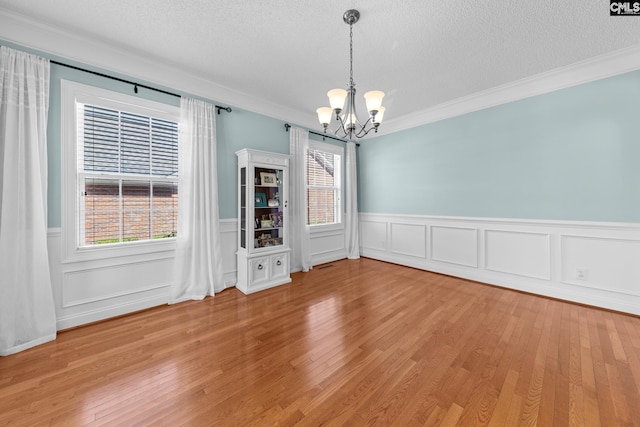 257 Popes Ln, Lexington, SC 29072 - empty room featuring a chandelier, a wainscoted wall, crown molding, a textured ceiling, and light wood finished floors