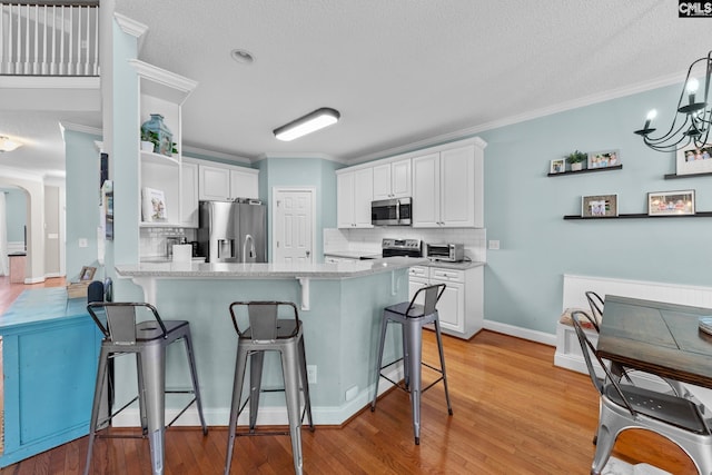 257 Popes Ln, Lexington, SC 29072 - kitchen with stainless steel appliances, a peninsula, decorative backsplash, crown molding, and a kitchen breakfast bar