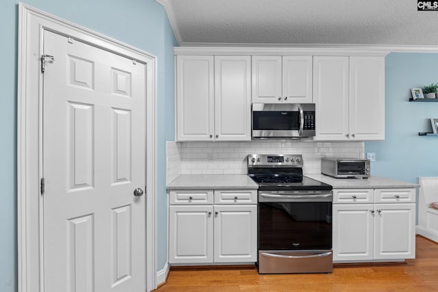 257 Popes Ln, Lexington, SC 29072 - kitchen featuring appliances with stainless steel finishes, decorative backsplash, white cabinetry, a textured ceiling, and ornamental molding