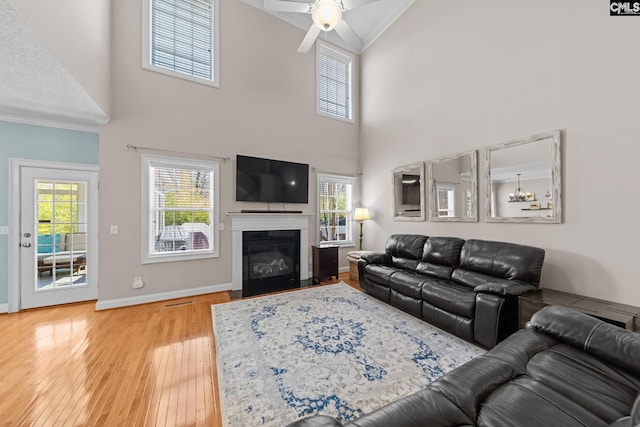 257 Popes Ln, Lexington, SC 29072 - living area featuring a ceiling fan, crown molding, a fireplace with flush hearth, hardwood / wood-style flooring, and high vaulted ceiling