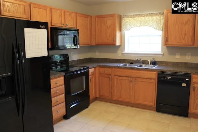 kitchen with a sink, black appliances, and dark countertops