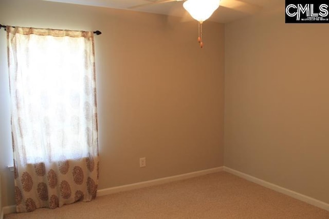 carpeted spare room with ceiling fan, baseboards, and plenty of natural light