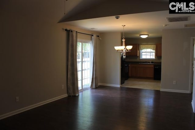 unfurnished room featuring wood finished floors, a sink, baseboards, visible vents, and a notable chandelier