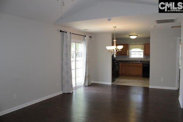 interior space featuring wood finished floors, vaulted ceiling, ceiling fan with notable chandelier, baseboards, and visible vents